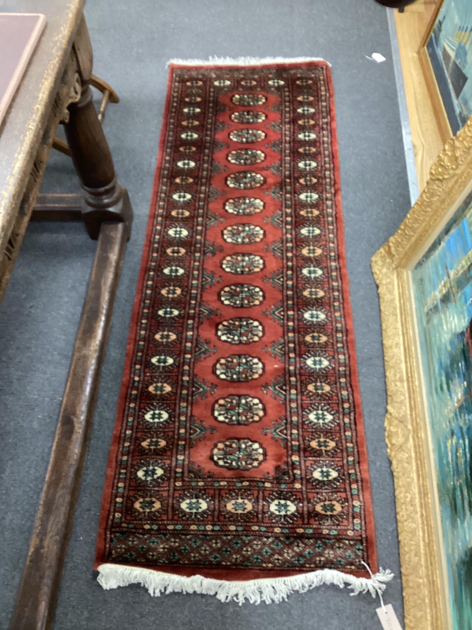 A Bokhara style red ground rug, 190 x 62cm